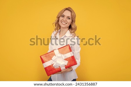 woman smile with big present box on yellow background