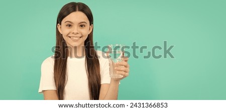 teen girl going to drink mineral beverage. healthy childhood lifestyle. water balance. Banner of child girl with glass of water, studio portrait with copy space. Royalty-Free Stock Photo #2431366853