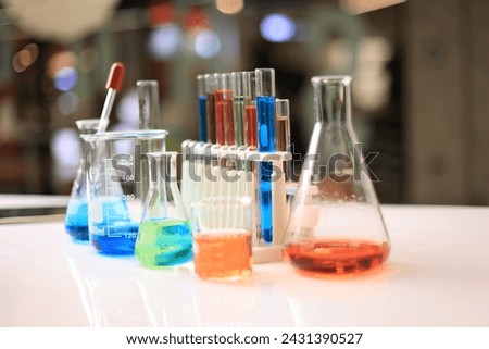 Colorful rows of laboratory test tubes and microscope with metal lens, science background. Test tube row. Concept of medical or science laboratory, close up, macro photography picture.