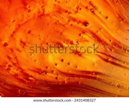 Abstract mother-of-pearl background in red with a golden sheen. The texture of the liquid is red-orange