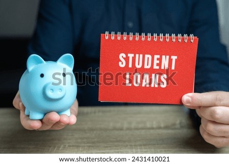 Student loans concept. Financial aid provided to students to help cover the cost of higher education. Note in male hands and pig piggy bank Royalty-Free Stock Photo #2431410021