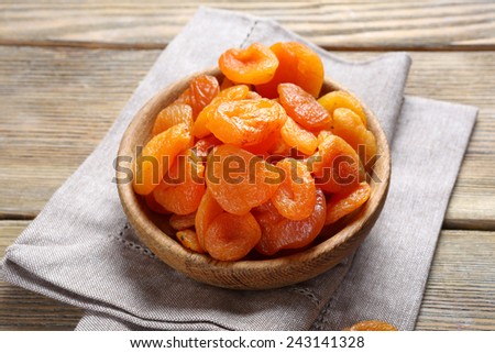Delicious dried apricots in a bowl on napkin, food Royalty-Free Stock Photo #243141328
