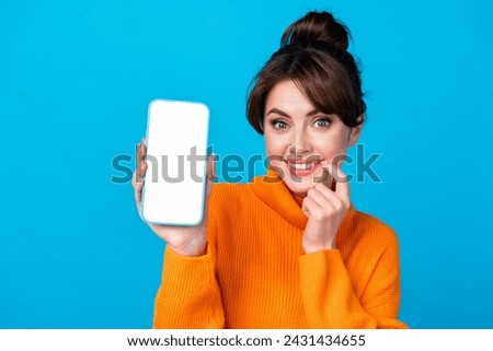 Photo of cute tricky woman dressed orange sweater texting modern device empty space isolated blue color background