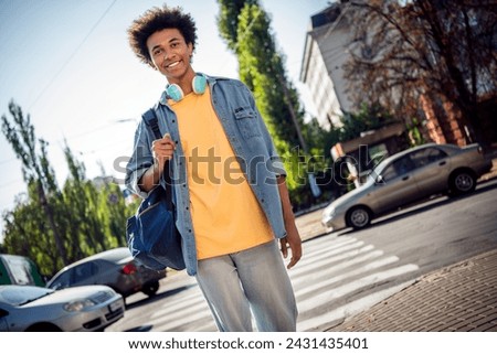 Photo of funny excited guy wear denim jacket earphones crossing road zebra outside urban city street