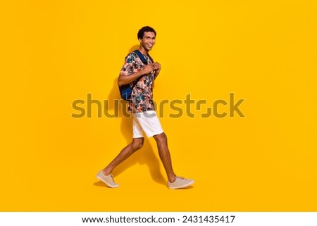 Full body length photo of young tourist guy with backpack strolling near empty space old city trip isolated on yellow color background