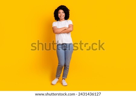 Full length photo of dreamy cheerful lady dressed white t-shirt arms folded looking empty space isolated yellow color background