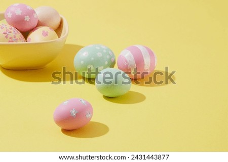 Easter eggs are painted with cute patterns and colors decorated on a yellow background. Holiday concept with copy space. Happy Easter