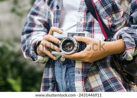 Close-up of an unrecognizable woman taking photos with analog camera