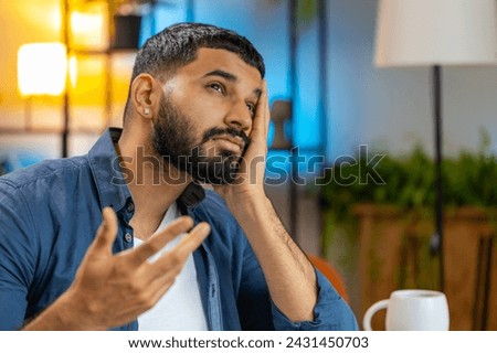 Overtired Indian man freelancer bored with laptop while sitting at home office. Stressed upset Arabian business executive cannot concentrate on work. Male worker is not interested in doing project. Royalty-Free Stock Photo #2431450703