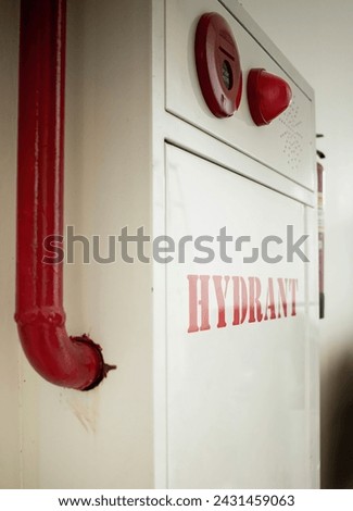 Fire extinguisher and water pump system on wall background, powerful emergency equipment for industry and residential
