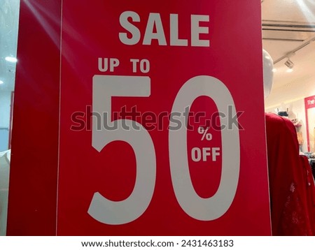 Red sign Sale up to 50 percentage off in shop window display