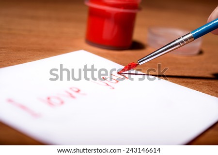 Valentine's Day drawing. woman's hand draws a brush inscription love