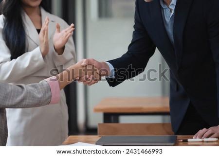 Happy business people shaking hands on a successful meeting in the office.
