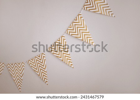 Festive chevron patterned bunting against a white wall. Minimalist design with copy space. Concept for event decoration, celebratory atmosphere.