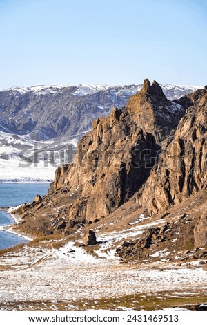 
The river froze, forming an icy panel that stretches between the rocks, like a silver bridge connecting the inaccessible cliffs on both sides. Royalty-Free Stock Photo #2431469513