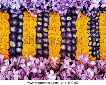 In the picture is a decoration of fresh flowers as pictured, including purple and white amaranths, salt-colored zinnias, and purple orchids.