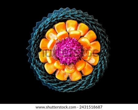 The white background in the picture is made from green rope and made into a circle inside, decorated with orange corn kernels and a pink amaranth flower in the middle.