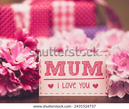 The image is a cake with a message written on it. The message on the cake says "MUM I Love You." The cake is decorated with pink and magenta floral designs.
