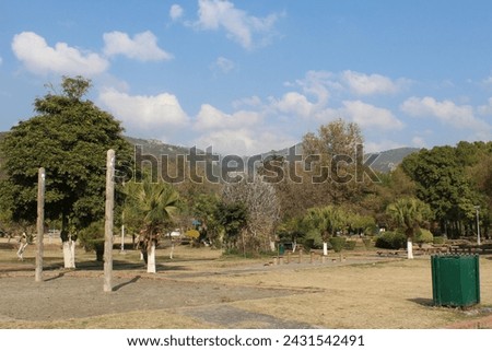 The blue sky over the trees. Summer landscape in mountains and the dark blue sky with clouds giving a beautiful effect to the landscape.