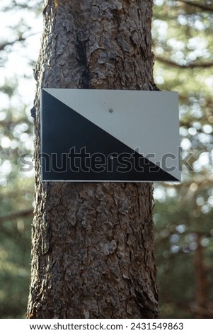 Hunting preserve warning sign on the trunk of a pine tree. Danger sign in the forest, in the Sierra de Guadarrama National Park, Madrid, Spain.