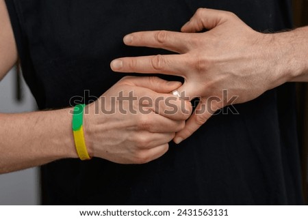 The man struggles to remove the wedding ring from his finger