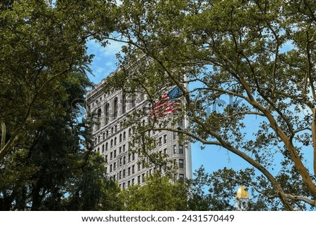 The American Flag and the Flatiron Building seen from the Trees of Madison Square Park - Manhattan, New York City