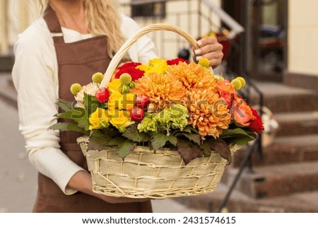 Girl florist holding basket of flowers her hands.flower composition.Floristry courses.photography with fresh flowers. sale of flowers flower shop.big basket with roses Royalty-Free Stock Photo #2431574615