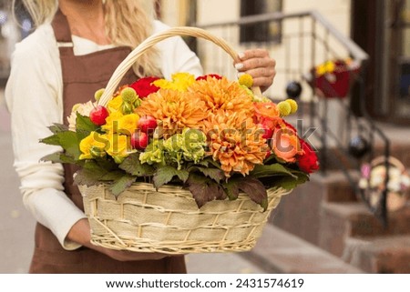 Girl florist holding basket of flowers her hands.flower composition.Floristry courses.photography with fresh flowers. sale of flowers flower shop.big basket with roses Royalty-Free Stock Photo #2431574619