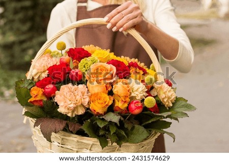 Girl florist holding basket of flowers her hands.flower composition.Floristry courses.photography with fresh flowers. sale of flowers flower shop.big basket with roses Royalty-Free Stock Photo #2431574629