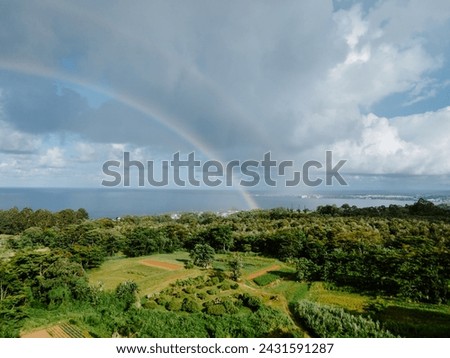 Rainbow over Hilo taken by drone. You can see the slight double rainbow and also pictured is farm lands. 