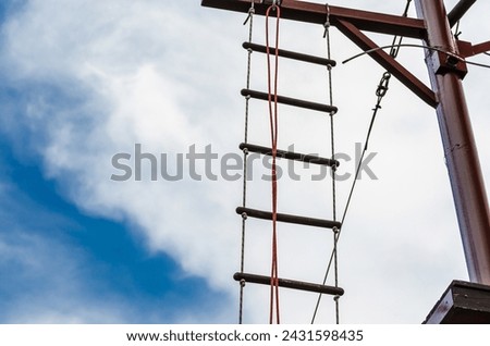 rope ladder against a blue sky and clouds Royalty-Free Stock Photo #2431598435
