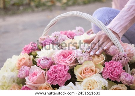 Girl florist holding basket of flowers her hands.flower composition.Floristry courses.photography with fresh flowers. sale of flowers flower shop.big basket with roses.flower seller Royalty-Free Stock Photo #2431611683