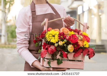 Girl florist holding basket of flowers her hands.flower composition.Floristry courses.photography with fresh flowers. sale of flowers flower shop.big basket with roses Royalty-Free Stock Photo #2431611737