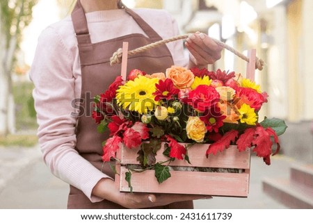 Girl florist holding basket of flowers her hands.flower composition.Floristry courses.photography with fresh flowers. sale of flowers flower shop.big basket with roses Royalty-Free Stock Photo #2431611739