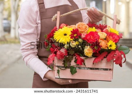 Girl florist holding basket of flowers her hands.flower composition.Floristry courses.photography with fresh flowers. sale of flowers flower shop.big basket with roses Royalty-Free Stock Photo #2431611741