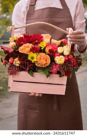 Girl florist holding basket of flowers her hands.flower composition.Floristry courses.photography with fresh flowers. sale of flowers flower shop.big basket with roses Royalty-Free Stock Photo #2431611747