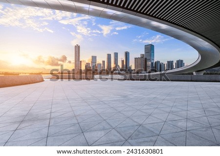 Empty square floor and pedestrian bridge with modern city buildings scenery at sunset