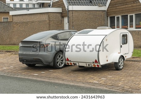 passenger car and a white mini caravan are both parked outside in a parking lot Royalty-Free Stock Photo #2431643963
