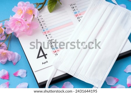 April, hay fever, infectious disease prevention, masks. The month and day of the week are written in English on the calendar. Royalty-Free Stock Photo #2431644195
