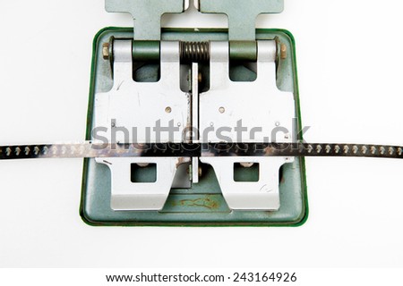 Detail of 8mm vintage splicer with film, isolated on white background