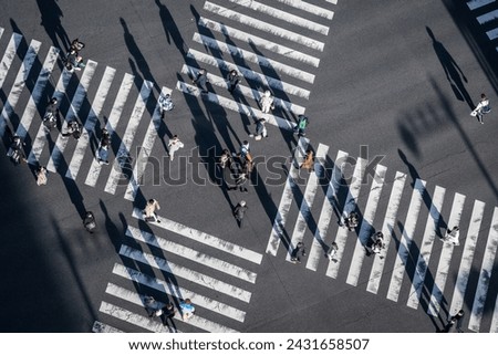 Pedestrians crossing the street at a busy intersection in Ginza, a popular upscale shopping area of Tokyo, Japan. Royalty-Free Stock Photo #2431658507