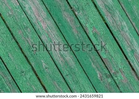 It's close up view of old green painted wooden fence. It is photo of a weathered painted wood texture. It is photo of aged green fence