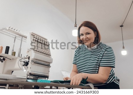 girl works on an embroidery machine at home, sets up and prepares the machine for work