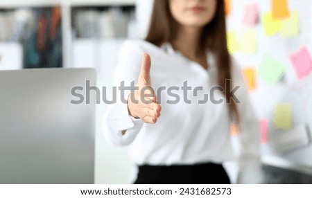 Cheerful female clerk welcoming business partner by shaking hand as sign of future achievements and prospects closeup