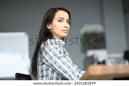 Close-up of beautiful young woman sitting in personal office. Luxury presentable suit on company worker. Copy space in right side. Business and secretary concept Royalty-Free Stock Photo #2431682899