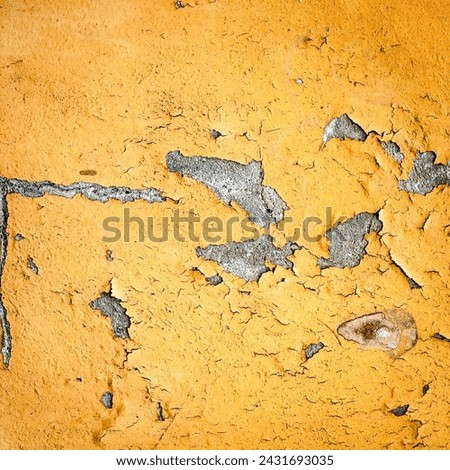 Close-up of a weathered yellow wall with chipped paint, revealing underlying textures. Rough texture due to years of exposure. Ideal for backgrounds or texture overlays.