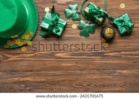 Leprechaun hat with pot of golden coins and gift boxes on wooden background. St. Patrick's Day