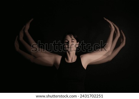 Stroboscopic photo of young woman with moving hands on dark background