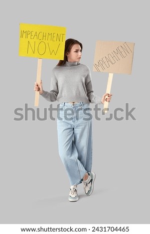 Protesting young woman with placards on light background. Impeachment concept