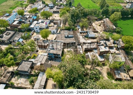 Aerial drone shot of an indian village with lush green farms and small houses